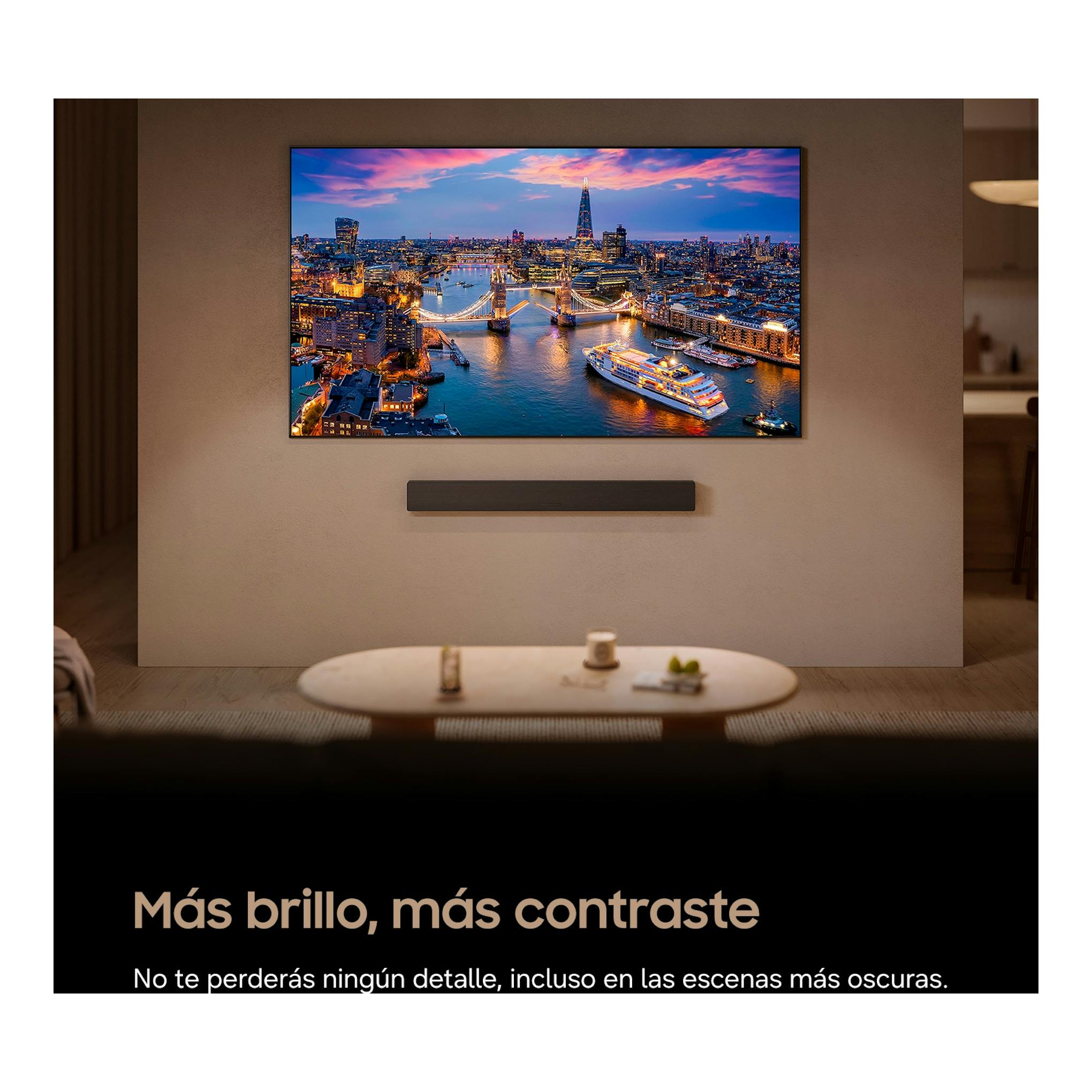 Televisor OLED Samsung TQ55S83HAEXXC montado en pared, con imagen nocturna de ciudad y barra de sonido.