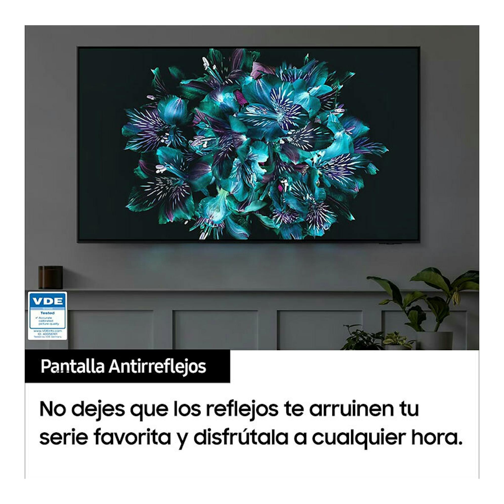 TV Samsung TQ65S90CATXXC montado en pared, vista frontal, pantalla con flores turquesa sobre fondo oscuro.