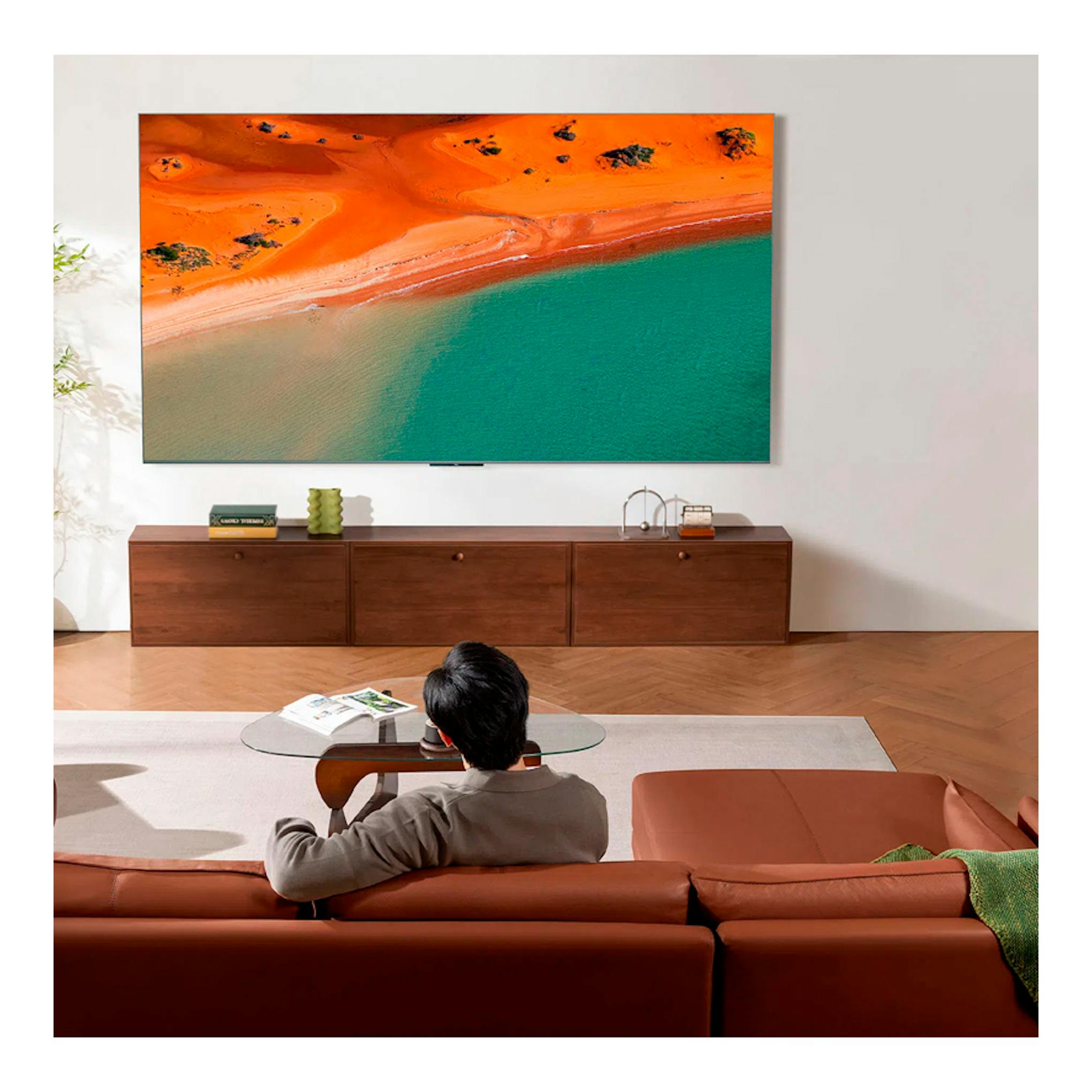 Televisor TCL 65C8K MiniLED 4K de 65 pulgadas, montado en pared, con imagen aérea de playa y mar.
