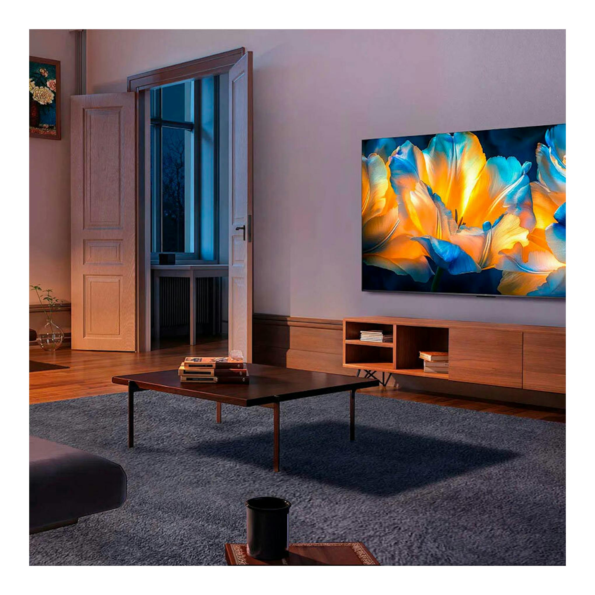 TV TCL 85C6K MiniLED 4K de 85 pulgadas, vista frontal montada en pared, con imagen de flores de colores.